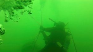 Diver adjusting the mooring lines of the Otsego Lake Buoy